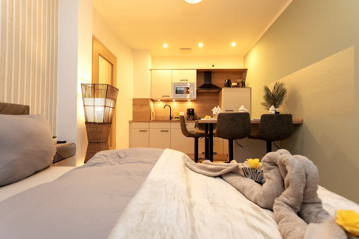 Gemütliches Zimmer des Koala-Apartments in Leipzig mit Bett und moderner Küchenzeile