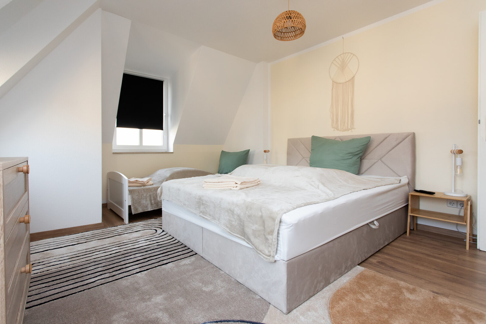 Schlafzimmer mit großem Doppelbett und Kinderbett