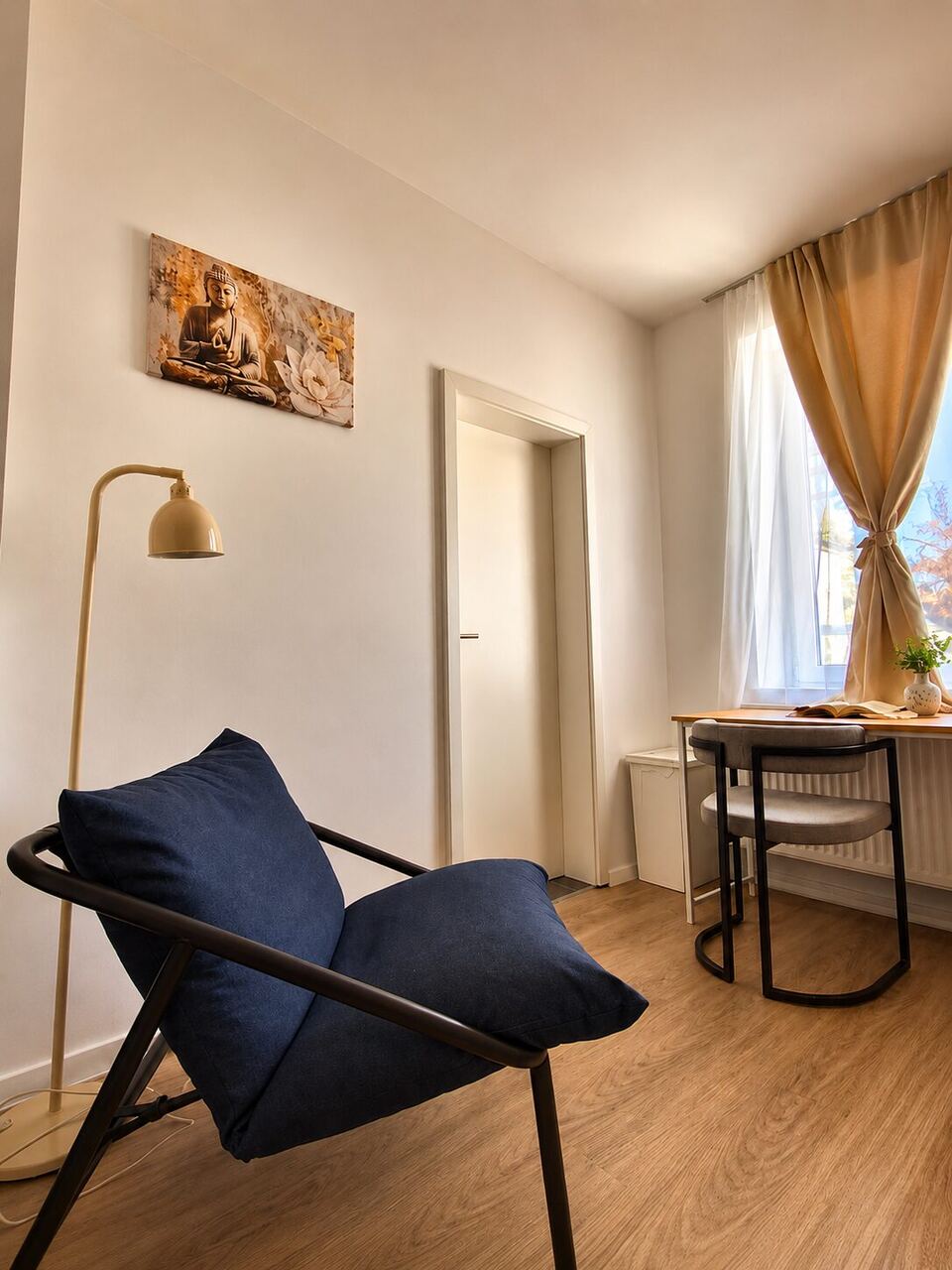 Sitzecke mit blauem Sessel und Stehlampe