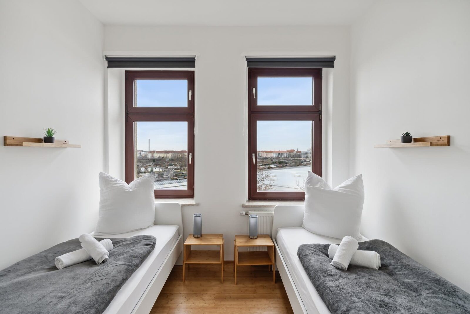 Schlafzimmer mit zwei Einzelbetten und zwei Fenstern