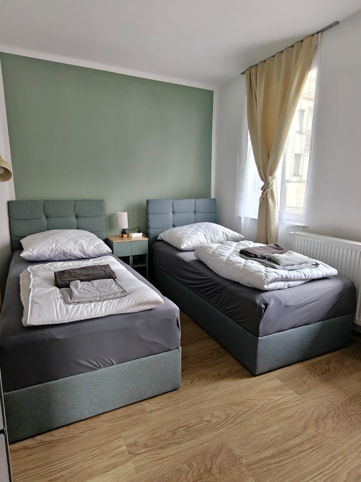 Zweibettzimmer mit Fenster und salbeigrüner Wand